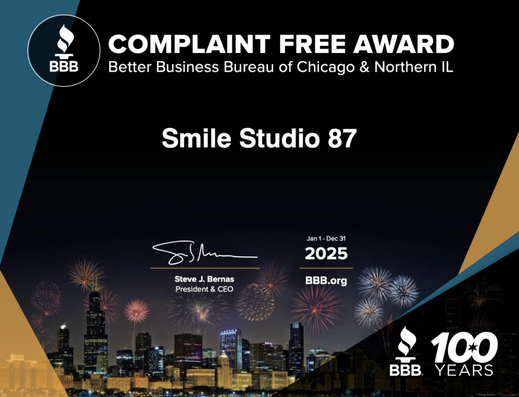 Award certificate from the Better Business Bureau of Chicago for Smile Studio 87, labeled 'Complaint Free Award 2025,' featuring Chicago skyline and fireworks.
